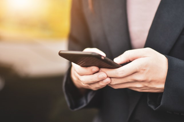 Mann tippt in Smartphone.